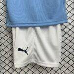 Maglia bambini Manchester City 25/26, taglie 16-28, design blu, ideale per allenamento e partite.